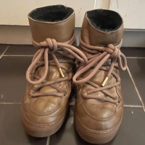 Bruna Inuikiis  - Säljer ett par bruna inuikiis i skinn med cool snörning. De har en högre skaft och ser riktigt mysiga ut för höst och vinter. Perfekta för att hålla fötterna varma och stiliga. Jag köpte dessa från NK för 3100kr och säljer de för 2000kr. De har använts i ungefär 1-2 år och är i bra skick! Skorna är i storlek 39 men passar även i storlek 38 och 40!!