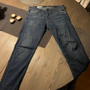 Mörkblå jeansbyxor Replay Anbass - Säljer ett par mörkblå Replay jeans i bra skick. De har en klassisk femficksdesign med dragkedja och knapp framtill. Jeansen har en straight passform och är perfekta för både vardag och fest. dem ser riktigt snygga och är bekväma att bära.