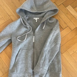 Helmut Lang Zip Huvtröja - Helmut Lang Zip Huvtröja i storlek Medium. Tröjan är i extremt bra skick utan fläckar eller skador (Som Ny). Mått: 63cm i längd (från axeln ner), 52 cm i axelbredd, 50 cm i bröstbredd. Känn dig fri att fråga om du undrar något mer.