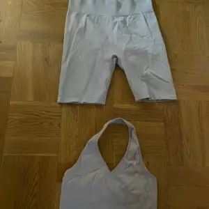 Säljer ett set med ljuslila ribbade shorts och matchande topp. Shortsen har en hög midja och är i ett mjukt, stretchigt material som passar perfekt för träning eller en avslappnad dag. Storlek L i shortsen och M i toppen.