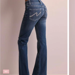 Lågmidjade nelly jeans🤍 - Säljer nu dessa populära lågmidjade nelly jeans!🤍 De har jättefina detaljer på bakfickorna och är i jättefint skick förutom att jag har trampat upp de pyttelite då de är för långa på mig men det syns bara om man kollar på nära håll! Storlek 38 men de har mycket stretch och passar både mindre och större, nypris är 699❤️Skriv vid frågor och skicka gärna prisförslag