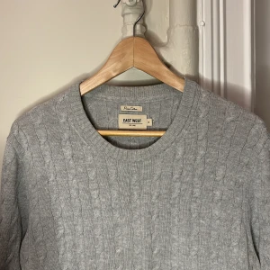 Kabelstickad - En kabelstickad tröja från East west i storlek M. Jätte fint skick inga defekter