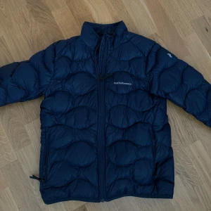 Peak performance dunjacka - Dunjacka för barn i strl 160, passar som en xs, superfin blå färg. Perfekt nu till höst. Den har ej större defekter. Pris kan diskuteras vid snabb affär!!🥰