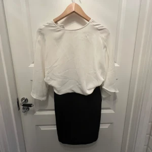 Klänning - Svart och vit klänning med knapp på baksidan, passar både som formellt och fin-plagg. Oanvänd!!!