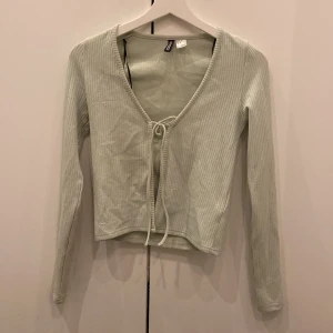 Ljusgrön ribbad kofta från H&M Divided - Säljer en superfin ljusgrön kofta från H&M Divided. Den är ribbad och har en söt knytning framtill. Perfekt för både vår och sommar! Den är i storlek XS. Använd några gånger men i bra skick.