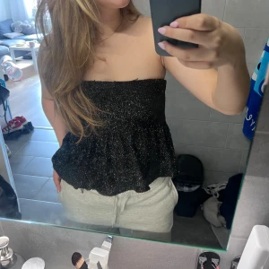 Svartglittrig festtopp - En skitsnygg svartglittrig bandeautopp i M men passar mig som är en S! Bara använd en gång💕 