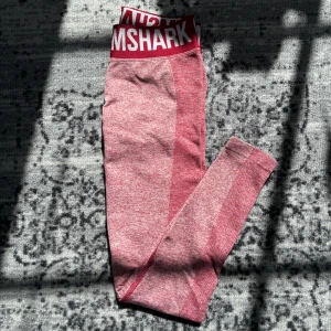 Tränings tights gymshark - Fina gymshark tights som är i nyskick. Knappast använda. Jag skulle säga att det är lite vinröda, men också nästan lite mörk rosa❤️nypris är nog ca.600kr