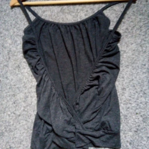 Ett mörk grått linne med öppning i ryggen  - I använt skick , sparsamt använd 😊 Ett jätte fint mörk grått linne med öppning i ryggen , inte för tunt och inte för sjokt material lite mittemellan skulle jag säga 😊 Fråga gärna för mer info vid intresse 💞😊