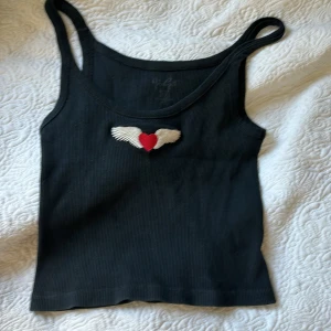 Brandy Melville tröja svart - Kort tank top linne från brandy Melville, svart med röd samt vita detaljer. 