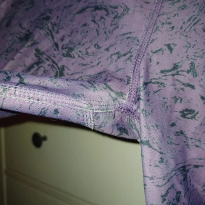 Lila leggings med mönster - Säljer ett par lila leggings med ett coolt mönster i mörkare nyanser. De är superbekväma och perfekta för både träning och chill. Materialet känns mjukt och stretchigt, vilket gör dem sköna att ha på sig hela dagen. Passar perfekt för dig som gillar att sticka ut lite! Slitna men inga hål, se bilder