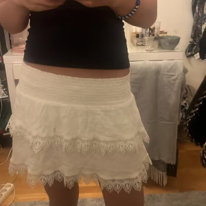 Vit mönstrad volang kjol - En vit gullig volang kjol med lite mönster på volangerna   Bra skick