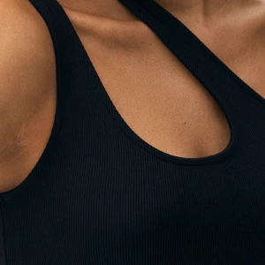 Svart ribbad linnetopp - Snygg svart ribbad linnetopp med en stilren design. Toppen har en tight passform och är ärmlös, perfekt för en trendig look. Materialet är mjukt och stretchigt för extra komfort. Sportbh/topp. EN L PASSAR ÄVEN M