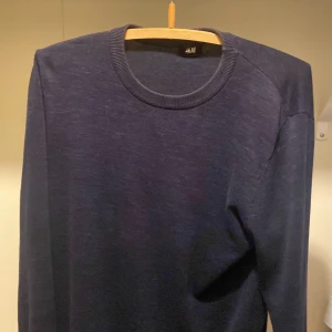 Mörkblå tröja från H&M - Säljer en stilren mörkblå tröja från H&M. Tröjan har en rund halsringning och långa ärmar, perfekt för en avslappnad look. Passar bra till både jeans och chinos. Perfekt för kyligare dagar!