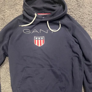 Mörkblå hoodie från GANT - En Mörkblå hoodie från GANT i väldigt bra skick.