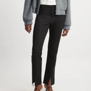 Svarta kostymbyxor med slits - Snygga svarta byxor med slits framtill. De har en fin passform och är perfekta för en stilren look och passar bra till både vardag och fest.