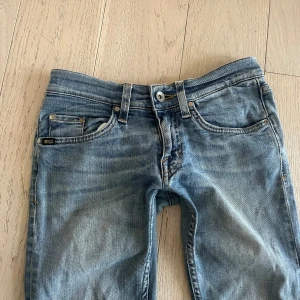 Blå jeansbyxor från tiger of sweden  -  Säljer dessa skitsnygga ljusblå jeansen från Tiger of Sweden . de är i väldigt fint skick och är utsydda på sidan för att få en mer bootcut passform. jag säljer dessa jeansen för att de är för små för mig då jag normalt har storlek S i jeans och är 165 cm lång och de är då för tajta på mig och för korta.