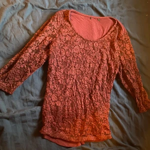 Vinröd spetsblus - Säljer en elegant vinröd blus med spetsdetaljer. Blusen har trekvartsärmar och en rund halsringning. Perfekt för en stilfull look.