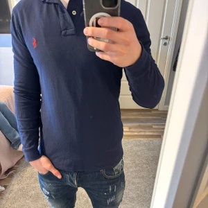Mörkblå långärmad pikétröja från Ralph Lauren - Säljer min killes Ralphlauren tröja i nyskick. Strl M passar även S. Skriv om du har frågor!