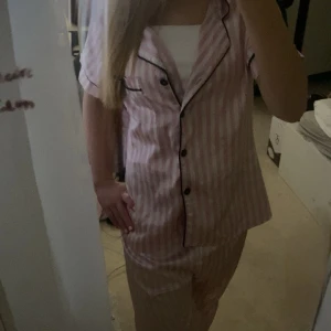 rosa/vit pyjamas i silke  - en fin rosa/vit randig pyjamas i silke  köpt från plick tidigare för ungefär 400kr använd få gånger och fortfarande fint skick byxorna är långa och passar mig som är ungefär 170cm och tröjan sitter nästan perfekt på mig som använder S 