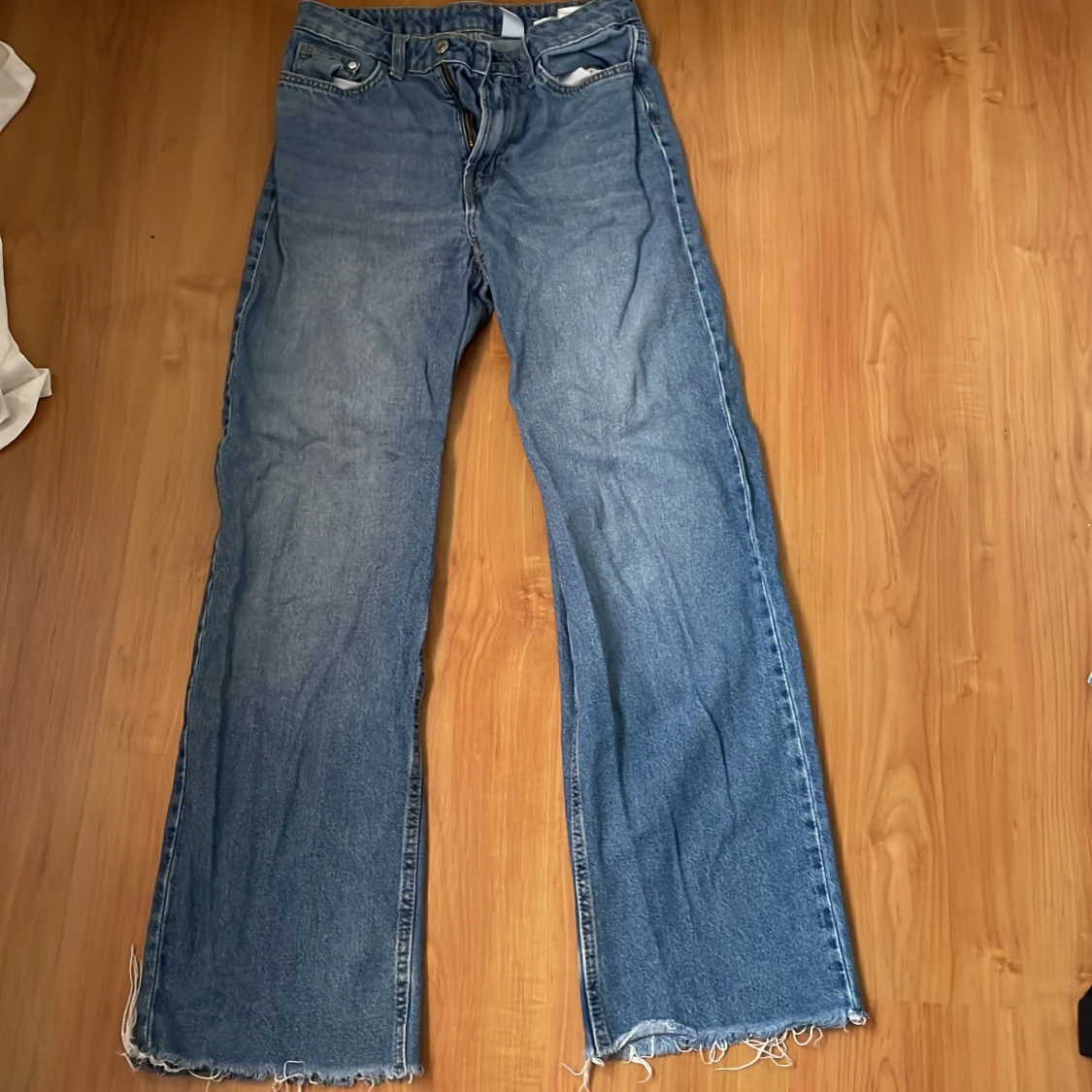 Blå jeans med fransiga kanter