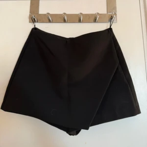Svart omlottkjol - snygg svart kjol med insydda shorts från zara, helt nya med prislapp.