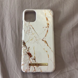 Mobilskal från Ideal of Sweden - Snyggt mobilskal från Ideal of Sweden med marmormönster i vitt och guld. Jätte fint skick, ser oanvänt ut! iPhone 11 Pro Max 