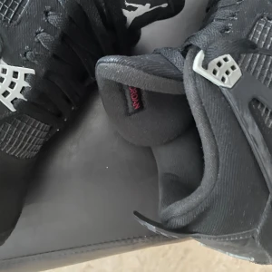 Nike Air Jordans 4 black canvas - Snygga svarta Nike Air Jordans med grå och vita detaljer. Skorna har en klassisk design med snörning och den ikoniska Jumpman-loggan på tungan och hälen. Perfekta för dig som vill ha en stilren och sportig look. De fraktas samma dag pch pris kan diskuteras 