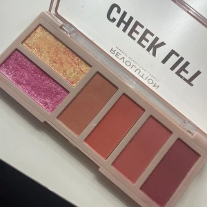 Cheek Lift Palette från Revolution - Upptäck Cheek Lift Palette från Revolution med sex fantastiska nyanser. Innehåller en mix av skimrande och matta färger i rosa, guld och brons. Perfekt för att skapa en strålande look med både highlighter och rouge. Endast testad!