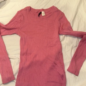 Rosa ribbad tröja - Säljer en snygg rosa ribbad tröja med långa ärmar. Perfekt för en stilren look och passar bra till både jeans och kjol. Tröjan har en enkel design som gör den lätt att matcha med andra plagg. Hör av dig vid intresse! 💖
