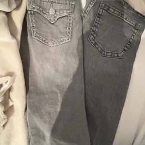 Grå jeans från Ginatricot - Snygga grå jeans från Ginatricot med coola detaljer på bakfickorna. Perfekta för en avslappnad stil. De har en klassisk femficksdesign och en knappgylf. Båda i storlek  146 (barn)💞 går att köpa styck, kontakta mig isåfall! HELT nya, aldrig använda ( dock inte lappen kvar) 🥰eftersom att de är helt nya och köps för nästan 400 st i butik så kostar båda tillsammans 400 nu för att jag har totalt köpt byxorna för runt 700 och de är ju helt nya!❤️