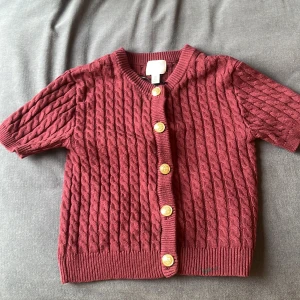 Vinröd stickad kofta från H&M - Tröja från H&M. Inte används så mycket men har blivit lite målarfärg på den.  Originalpris 200kr