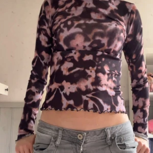 Mönstrad långärmad topp - Säljer en cool långärmad topp med ett unikt mönster i svart och rosa. Toppen har en tight passform och vågig kant vid nederdelen🩷skriv vid frågor/intresse