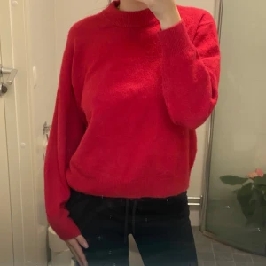 Rosa stickad tröja - Säljer en mysig stickad tröja med långa ärmar. Perfekt för kyligare dagar och ger en härlig färgklick till garderoben. Tröjan har en klassisk passform och är lätt att matcha med olika stilar.