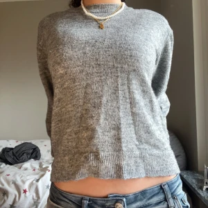 Grå stickad tröja - Säljer en mysig grå stickad tröja med ribbad nederkant. Perfekt för kyligare dagar och lätt att matcha med olika outfits. Storlek M men sitter fint på S och xs