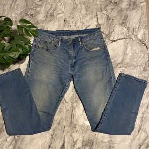 Blå jeans från Levi's - Säljer ett par klassiska blå Levi's  502 med snygga slipningar. DBlå jeans från Levi'som har W31 och längd 32. Priset kan gå ner.
