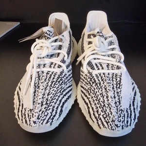 YEEZY BOOST 350 V2 ZEBRA - Snygga Adidas Yeezy Boost 350 V2 i den populära Zebra-färgen. Skorna har ett svartvitt mönster med röd text på sidan och en bekväm, ribbad sula. Perfekta för dig som vill ha både stil och komfort.Har order bekräftelse från Adidas för att bevisa att de är äkta.