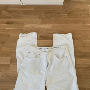 Vita low straight jeans - Snygga vita low straight jeans med klassisk design. De har en låg midja och raka ben, vilket ger en avslappnad look. Perfekta för en stilren outfit.
