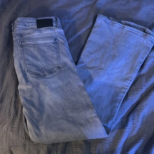 Blå jeans från 157 - Snygga blå jeans från 157 med låg midja och bootcut-stil. De har en klassisk femficksdesign och dragkedja. 