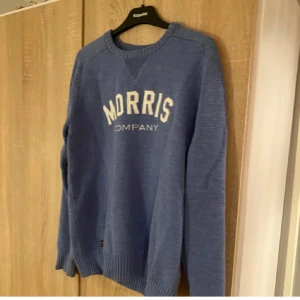 Blå tröja från Morris - Säljer en snygg blå tröja från Morris med texten 'Morris Company' i vitt på bröstet. Tröjan har långa ärmar och en ribbad detalj vid halsen. Perfekt för en stilren och avslappnad look.