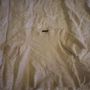 Beige tröja från Stockh lm - Säljer en stilren beige tröja från Stockh lm. Tröjan har korta ärmar och en rund halsringning. Perfekt för en avslappnad look. Köpt från MQ!!