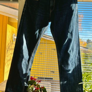 Levi's 511 Jeans - Säljer ett par snygga Levi's 511 jeans i mörkblå denim. De har en rak passform och klassiska gula sömmar. Perfekta för både vardag och fest! 🕺