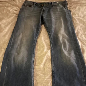 Blå jeans från Lee - Säljer ett par klassiska blå jeans från Lee i bra skick. De har en snygg tvättad look och är perfekta för vardagsbruk. Jeansen har en normal passform och är tillverkade i slitstarkt denim. Perfekta för både höst och vår!
