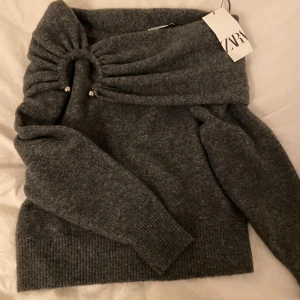 Grå off shoulder tröja från Zara - Säljer en snygg off shoulder tröja från Zara som är helt ny med prislappen kvar. Ursprungs priset är 400kr och den är slutsåld på Zara🌺