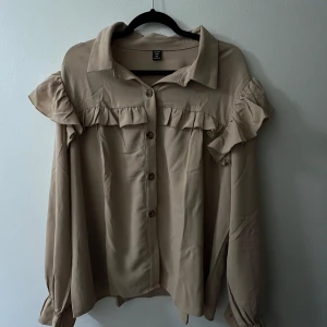 Höst Beige skjorta - En super fin skjorta med volangdetaljer, casual design med långärmar, lämplig för hösten. Storleken passar på alla från 1-3XL