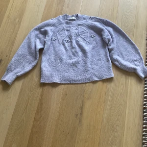 Ljuslila stickad tröja från mango - Stickad ljuslila tröja från mango!💜 Den har ett fint mönster med blommor 🌸 Stoleken är M men är liten i storleken så skulle säga att den är mellan XS-S!