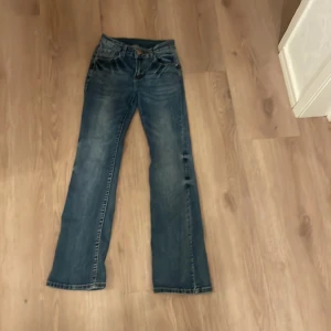 Blå bootcut jeans - Säljer ett par klassiska blå bootcut jeans i bra skick. De har en snygg tvätt och är perfekta för både vardag och fest. Jeansen har en normal passform och är tillverkade i slitstarkt denim. Perfekta för höst och vår!