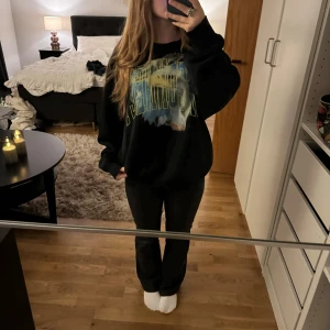 Svart sweatshirt med coolt tryck  - Säljer en svart sweatshirt med coolt tryck på framsidan. Den har en avslappnad passform och är perfekt för en chill dag hemma eller ute. Tröjan är i bra skick och superbekväm. Perfekt för höst och vinter! 💗