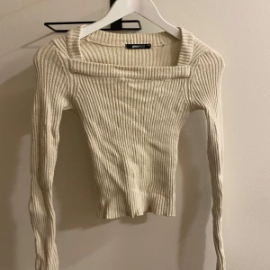 Beige ribbad tröja från Gina Tricot - Säljer en superfin vit ribbad tröja från Gina Tricot. Den har en unik fyrkantig halsringning och långa ärmar. Perfekt för vardagen! Passar bra till jeans eller kjol. 🧡