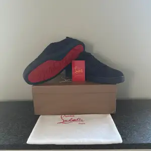 Säljer ett par snygga svarta sneakers från Christian Louboutin i nytt skick. Skorna har den ikoniska röda sulan. Kommer med originalkartong och dustbag. 