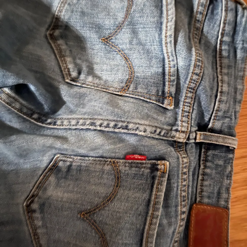 Säljer ett par blå Levis jeans i bootcut-stil. De har coola slitningar på ena benet🩷. Jeans & Byxor.